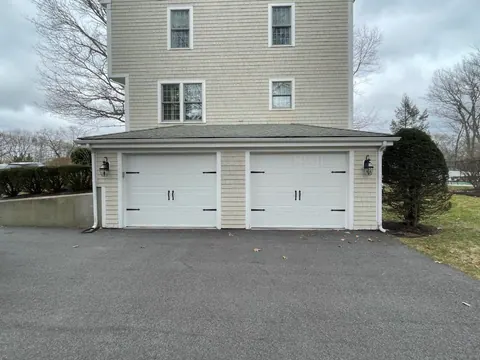 Two white carriage-style doors beneath an Abington home