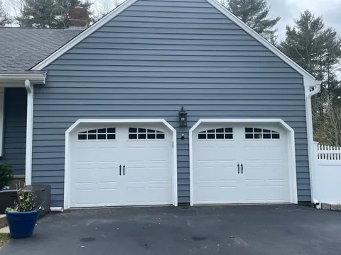 Two white garage doors with arched windows in Kingston