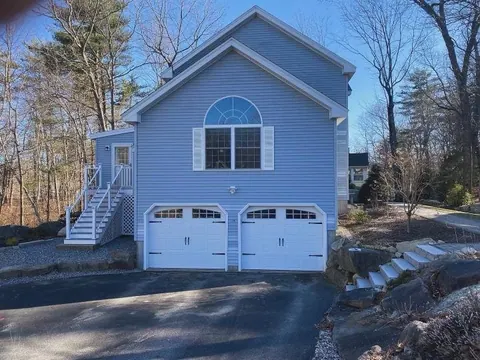 White carriage-style doors on a blue two-story garage in Marshfield