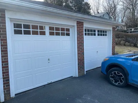 Two white carriage-style garage doors with windows in Quincy